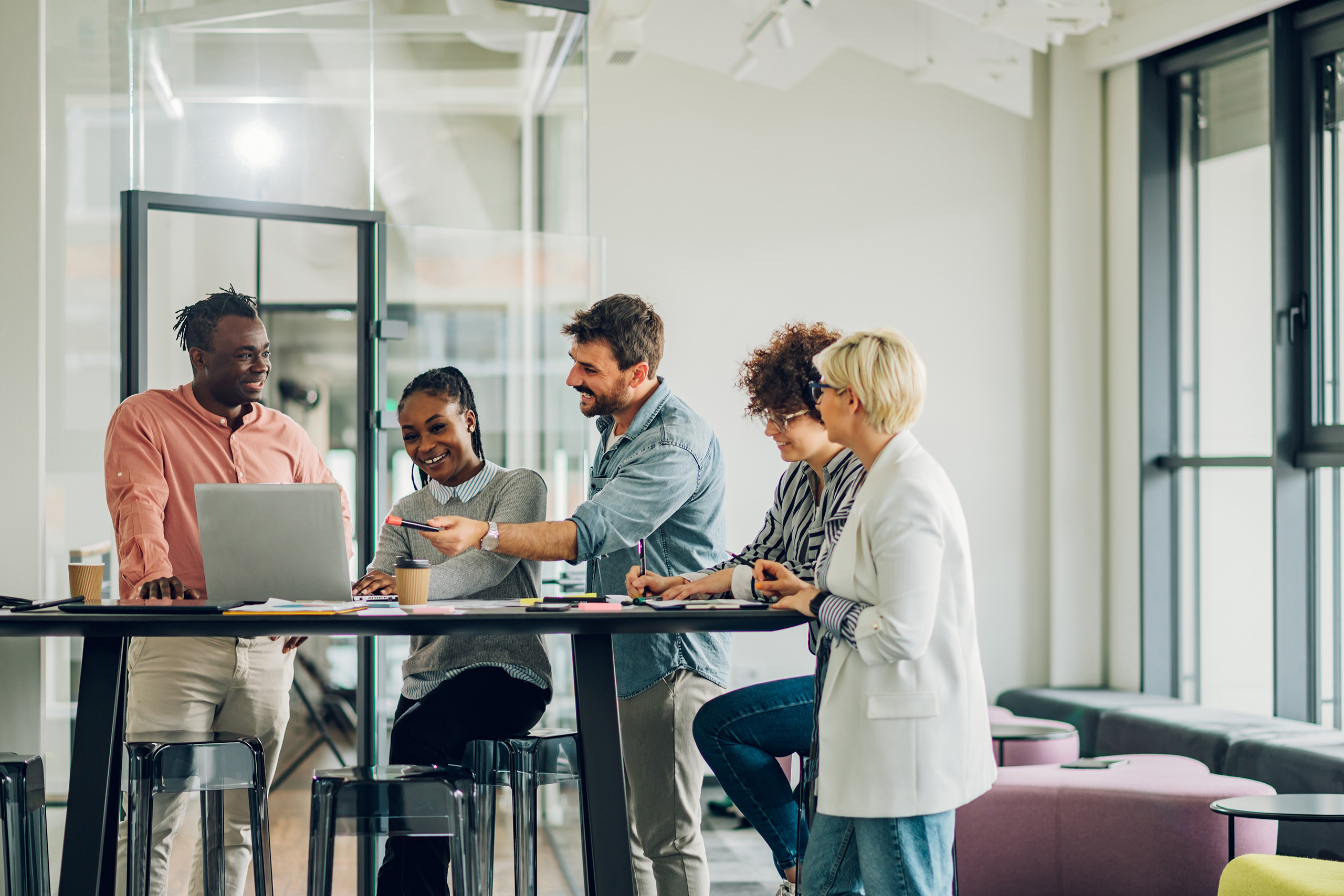 Diverse group of people collaborating around a desk in the office